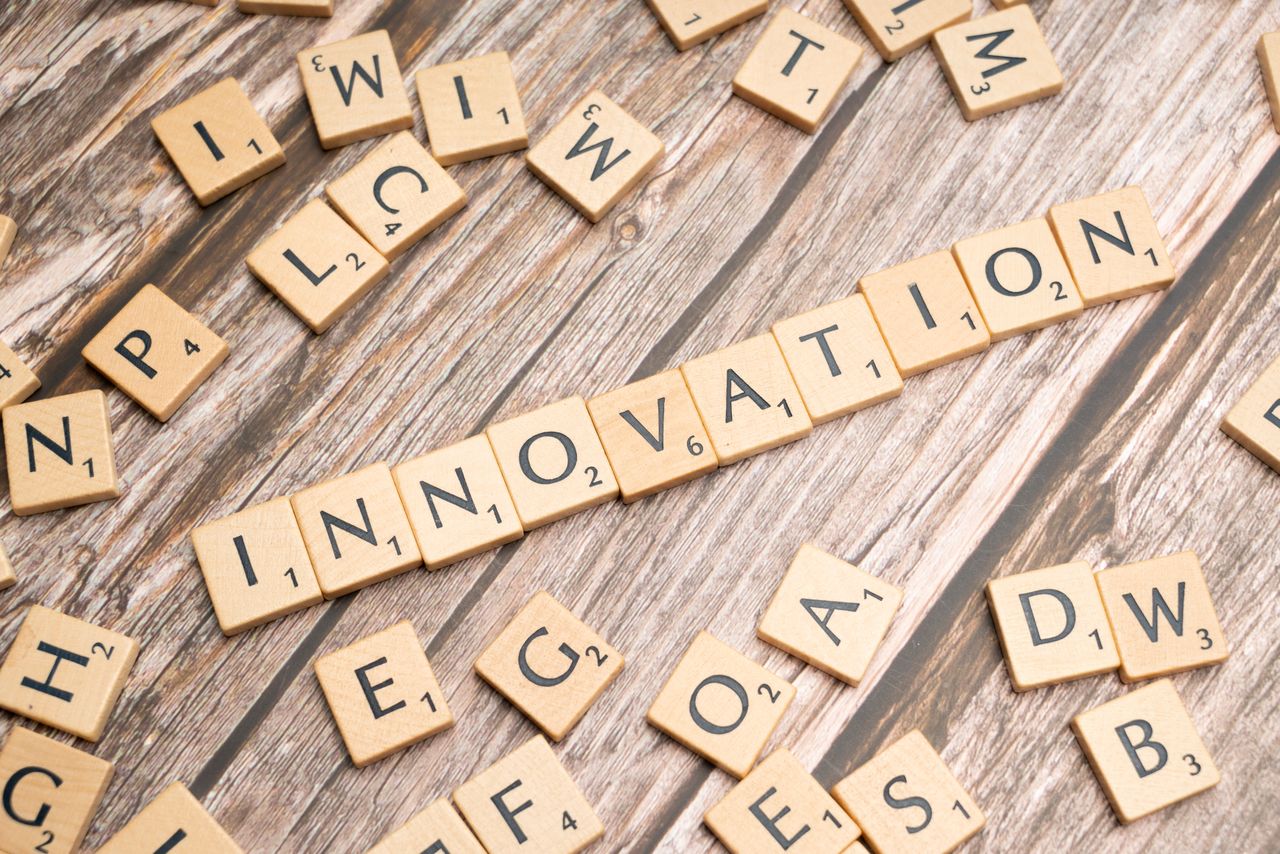 Creative display of Innovation spelled with wooden letter tiles on a wooden surface.
